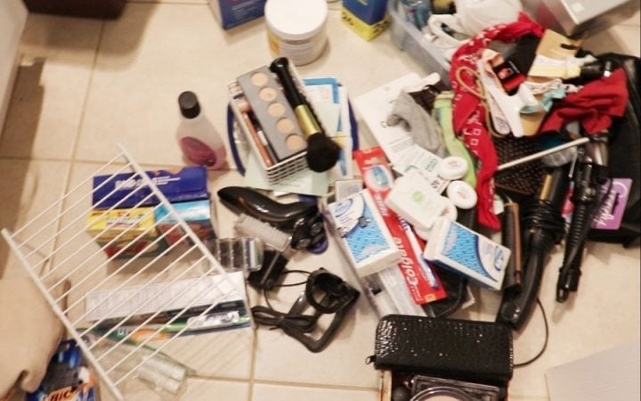 makeup, hair stuff and a bunch of vanity stuff scattered on a cream tile floor
